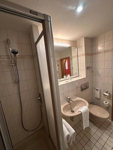 a bathroom with a sink and a shower with a mirror at Hotel Berliner Hof in Braunlage