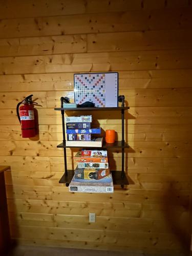 a shelf on a wall with books and a fire extinguisher at Large Cabin Perfect for families in Sevierville