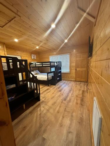 a room with two bunk beds and a wooden floor at Large Cabin Perfect for families in Sevierville