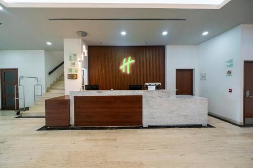 an office lobby with a reception desk and stairs at Holiday Inn Uruapan by IHG in Uruapan del Progreso