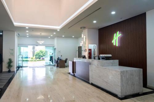 a lobby with a reception desk in a building at Holiday Inn Uruapan by IHG in Uruapan del Progreso