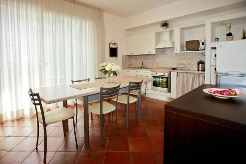cocina con mesa y sillas y cocina con nevera en B&B A casa di amici, en Giardini Naxos