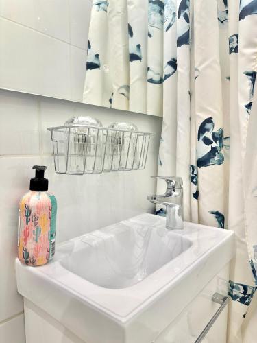 une salle de bains blanche avec lavabo et vase. dans l'établissement Elegant Apt Sleep 5 in Alasseur Near Eiffel Tower, à Paris