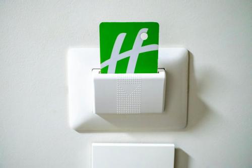 a green and white lightswitch on a white wall at Holiday Inn Uruapan by IHG in Uruapan del Progreso