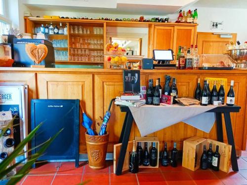 a bar with a table with bottles of wine at Gasthaus zum Halbmond in Speyer