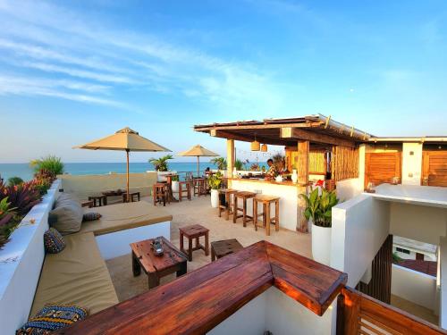 an outdoor patio with tables and chairs and the ocean at Aluna Beach Apartments in Nungwi