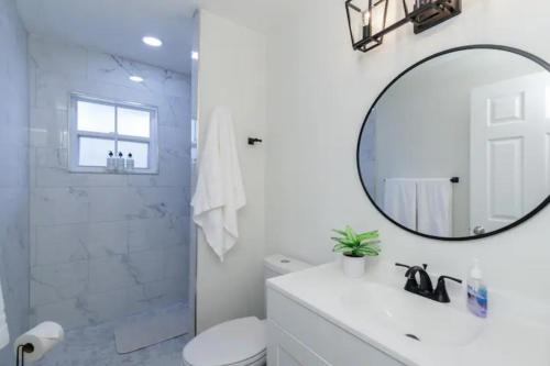 a white bathroom with a sink and a mirror at Dreamy Bay Apartment 2bed 1bath with full kitchen and laundry in Sarasota