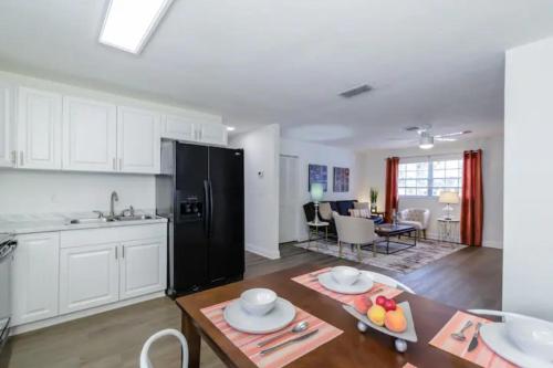 a kitchen and living room with a black refrigerator at Dreamy Bay Apartment 2bed 1bath with full kitchen and laundry in Sarasota