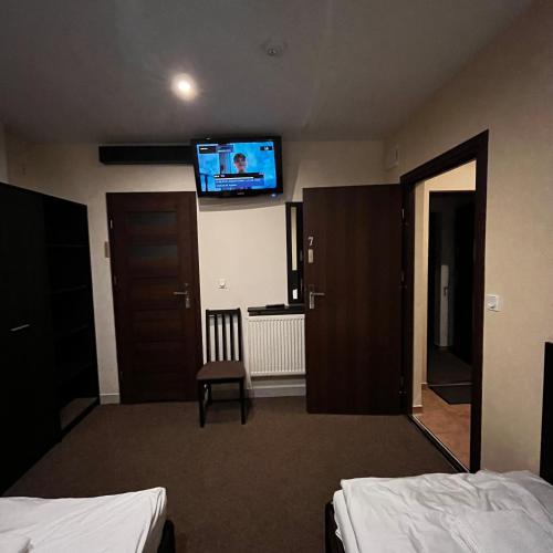 a hotel room with two beds and a flat screen tv at Valda House in Rybie