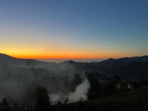 a sunset over the mountains with clouds in the valley at Çolakoglu konagı in Cayeli