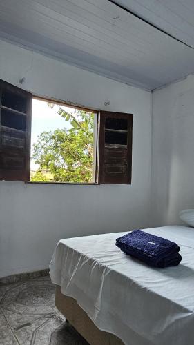 a white room with a bed and a window at LahSelva Pousada e Hostel in Itacaré