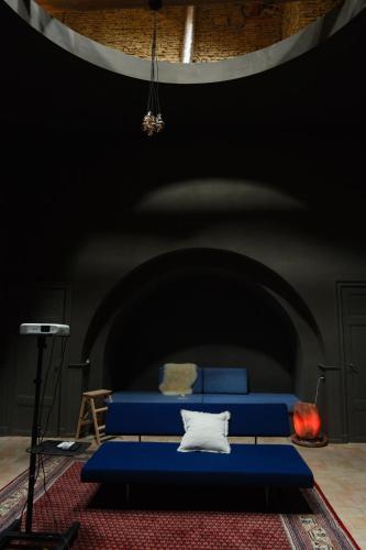 a blue bed in a room with a black wall at La Grande Maison de Migou in Larrazet