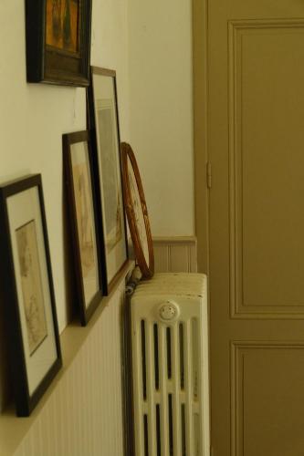 a hallway with a radiator and pictures on a wall at La Grande Maison de Migou in Larrazet