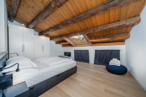 ウーディネにあるElegance in Udine! Matteotti Apartmentsの大きなベッドと木製の天井のある寝室