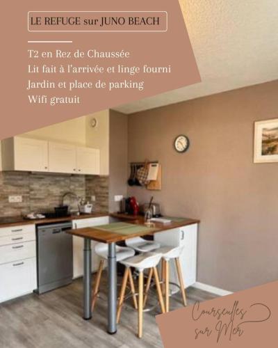 une cuisine avec une table et des chaises dans une pièce dans l'établissement Le Refuge Marin, à Courseulles-sur-Mer
