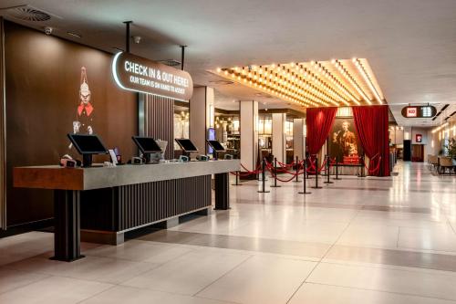 a lobby of a shopping mall with a reception counter at Radisson Hotel and Conference Centre London Heathrow in Hillingdon