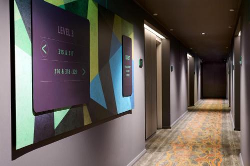 a hallway with a wall with colorful art on it at Holiday Inn Perth City Centre by IHG in Perth