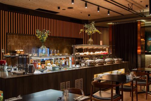 a restaurant with a bar with tables and chairs at Holiday Inn Perth City Centre by IHG in Perth