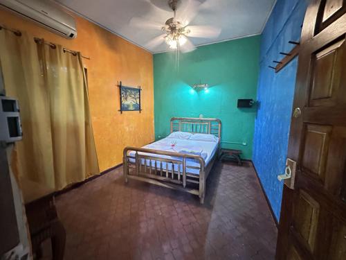 a small room with a bed with a blue and green wall at Chosa Manglar Suites & Cabins in Puerto Jiménez