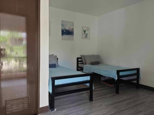 a room with two beds and a table and a window at LMS Guest House in Iloilo City