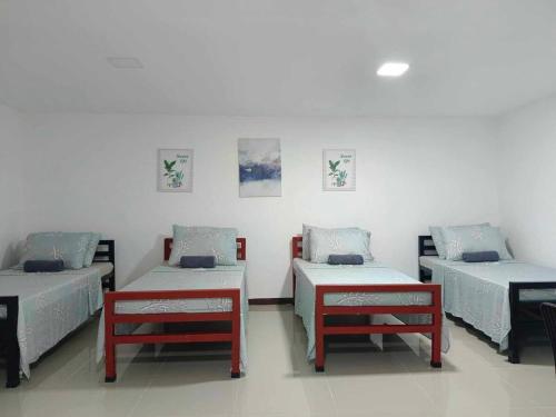 a room with three beds and two benches at LMS Guest House in Iloilo City