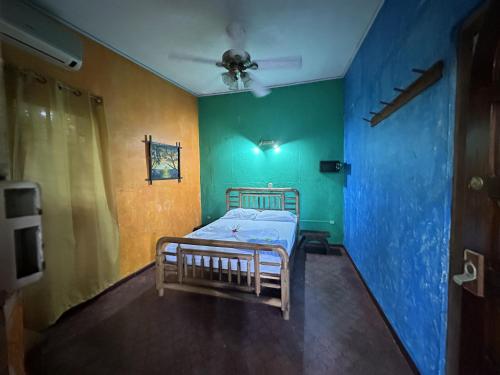 a bedroom with a bed with green and blue walls at Chosa Manglar Suites & Cabins in Puerto Jiménez