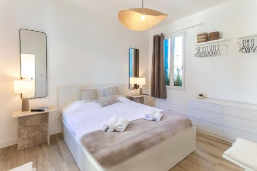 une chambre blanche avec un lit avec des serviettes dessus dans l'établissement 3P au coeur de Juan les Pins, à Antibes