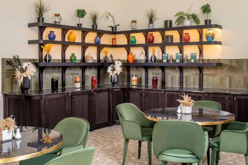 a restaurant with two tables and chairs and a shelf with vases at Radisson Blu Hotel Casablanca City Center in Casablanca