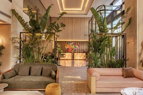 a lobby with two couches and plants at Radisson Blu Hotel Casablanca City Center in Casablanca