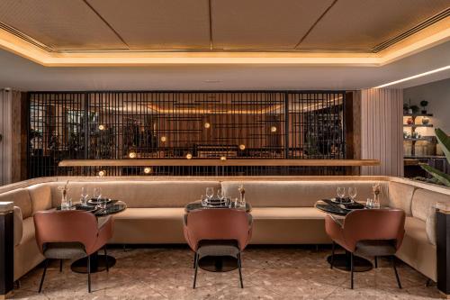 a restaurant with a long couch and tables and chairs at Radisson Blu Hotel Casablanca City Center in Casablanca