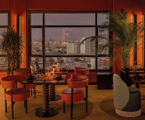 a restaurant with a table and chairs and a large window at Radisson Blu Hotel Casablanca City Center in Casablanca