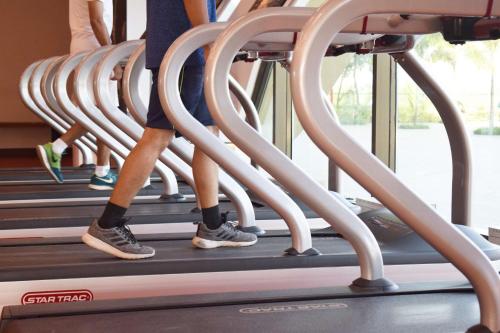 people walking on a treadmill in a gym at Gift City Club, a member of Radisson Individuals in Gandhinagar