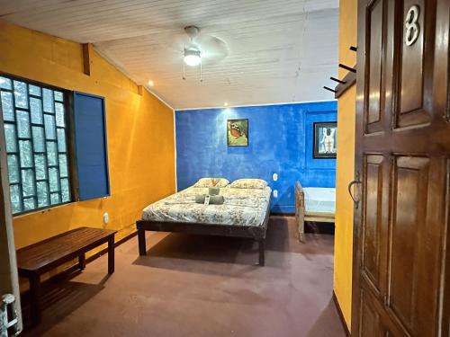 a bedroom with a bed and a bench in a room at Chosa Manglar Suites & Cabins in Puerto Jiménez