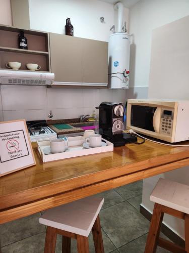 a kitchen with a counter with a microwave and a table at Real .Departamento in Luján