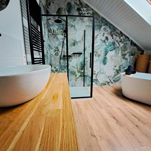 a bathroom with a tub and a glass shower at Chambre et salle de bain privative in Liège