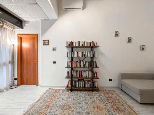 a living room with a book shelf filled with books at Two-room apartment in Segrate - Comfort, 10 minutes from Milano, Cortina 2026 Winter Olympics in Segrate