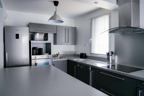 une cuisine avec des appareils en acier inoxydable et un comptoir blanc dans l'établissement Sporting House, à Toulouse