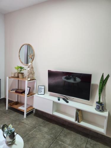 a living room with a tv on a white entertainment center at Real .Departamento in Luján