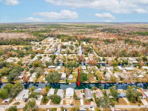 an aerial view of a residential neighborhood with a red arrow pointing to a house at The Hideaway at Weeki Wachee in Weeki Wachee