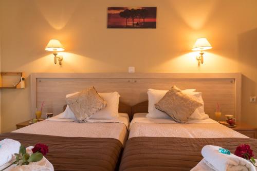 a hotel room with two beds and two lamps at Tasia Studios in Perivolion