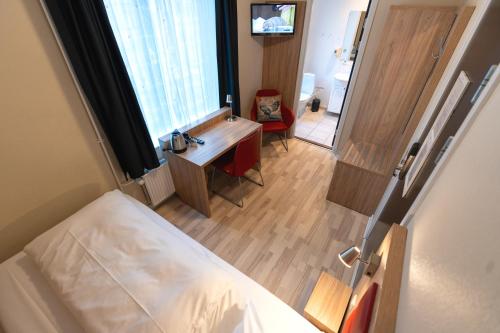 a bedroom with a bed and a desk and a window at Prinsen Hotel in Aalborg