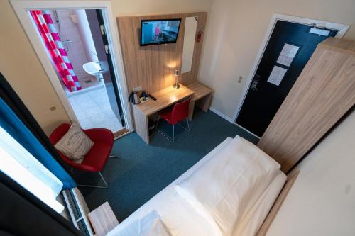 a hotel room with a bed and a desk and a mirror at Prinsen Hotel in Aalborg