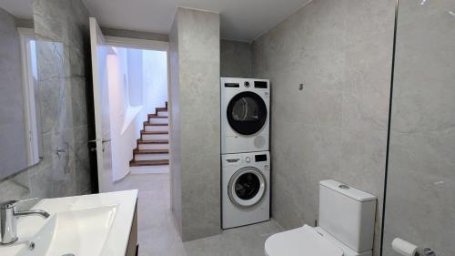 ein Badezimmer mit Waschmaschine und Trockner an der Wand in der Unterkunft Villa Galatea Stunning First Line Beachfront in Klorakas