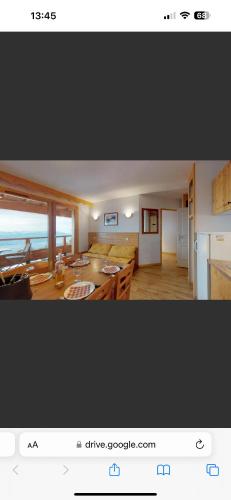 Il comprend une cuisine et un salon avec une table. dans l'établissement Chamrousse 1750 Aux pied des pistes, Super vue, à Chamrousse