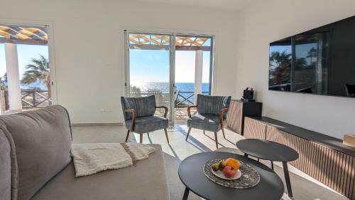 a living room with a couch and a table at Villa Galatea Stunning First Line Beachfront in Khlorakas