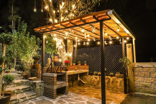 a wooden pergola with lights on a patio at ValZur Hospedaje: Suite Arces in Villa del Carbón