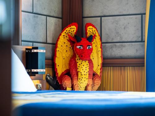 a red devil statue sitting next to a bed at LEGOLAND(R) Windsor Resort in Windsor