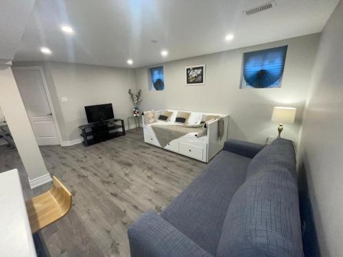 a living room with a couch and a bed at CozyHaven A private entrance, comfy basement apartment in Mississauga with free parking Conveniently located with easy access to the airport downtown Toronto major malls and highways for a seamless stay in Mississauga