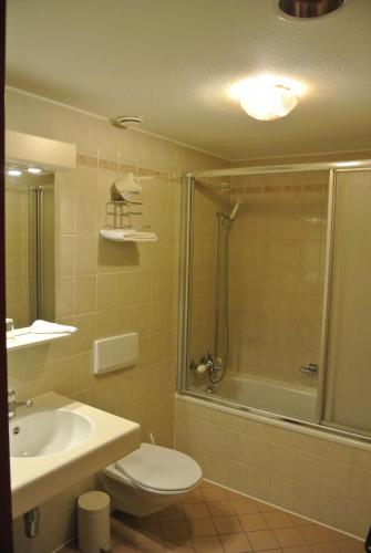 a bathroom with a toilet and a shower and a sink at Auberge de la Réunion in Coinsins