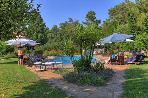 a pool with tables and umbrellas and people sitting around it at Dalya Life in Göcek